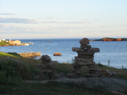 Inukshuk with rusting wreck to right